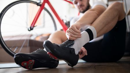 A man putting on shoes for indoor cycling